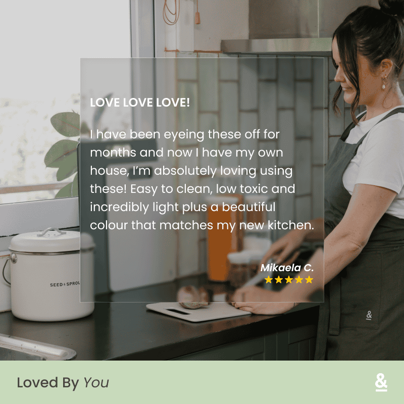 5-star customer review from Mikaela C. overlaid on a lifestyle photo of a person using a Wood Fibre Chopping Board in Mushroom on a dark kitchen countertop. Review reads: "Easy to clean, low toxic and incredibly light plus a beautiful colour that matches my new kitchen."