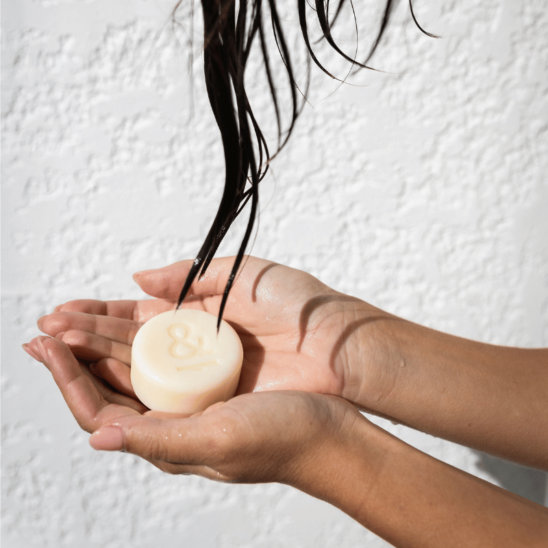 an anti-frizz australian made conditioner bar held in hands